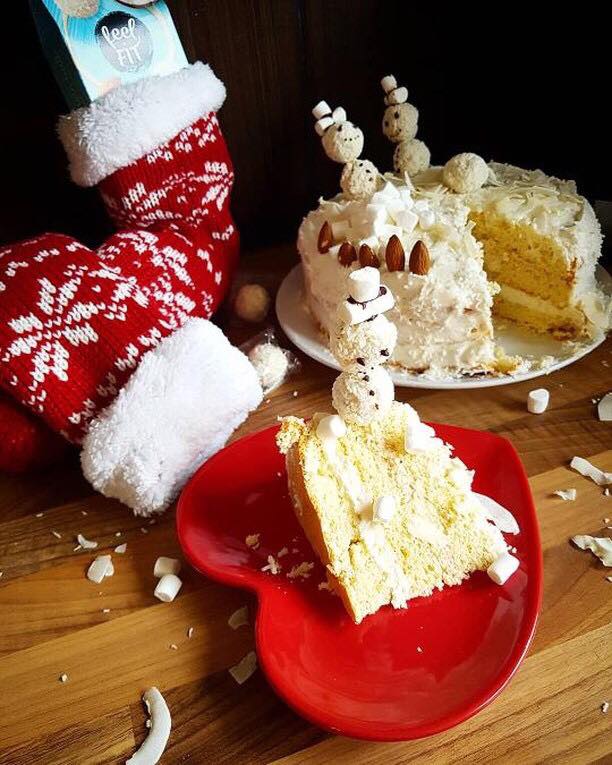 a piece of healthy cake with no added sugar, with almonds and protein coconut balls feel FIT which are snowmans on the christmas table